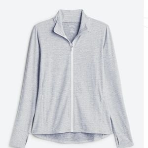 Grey and white zip up performance top with thumb holes and pockets
